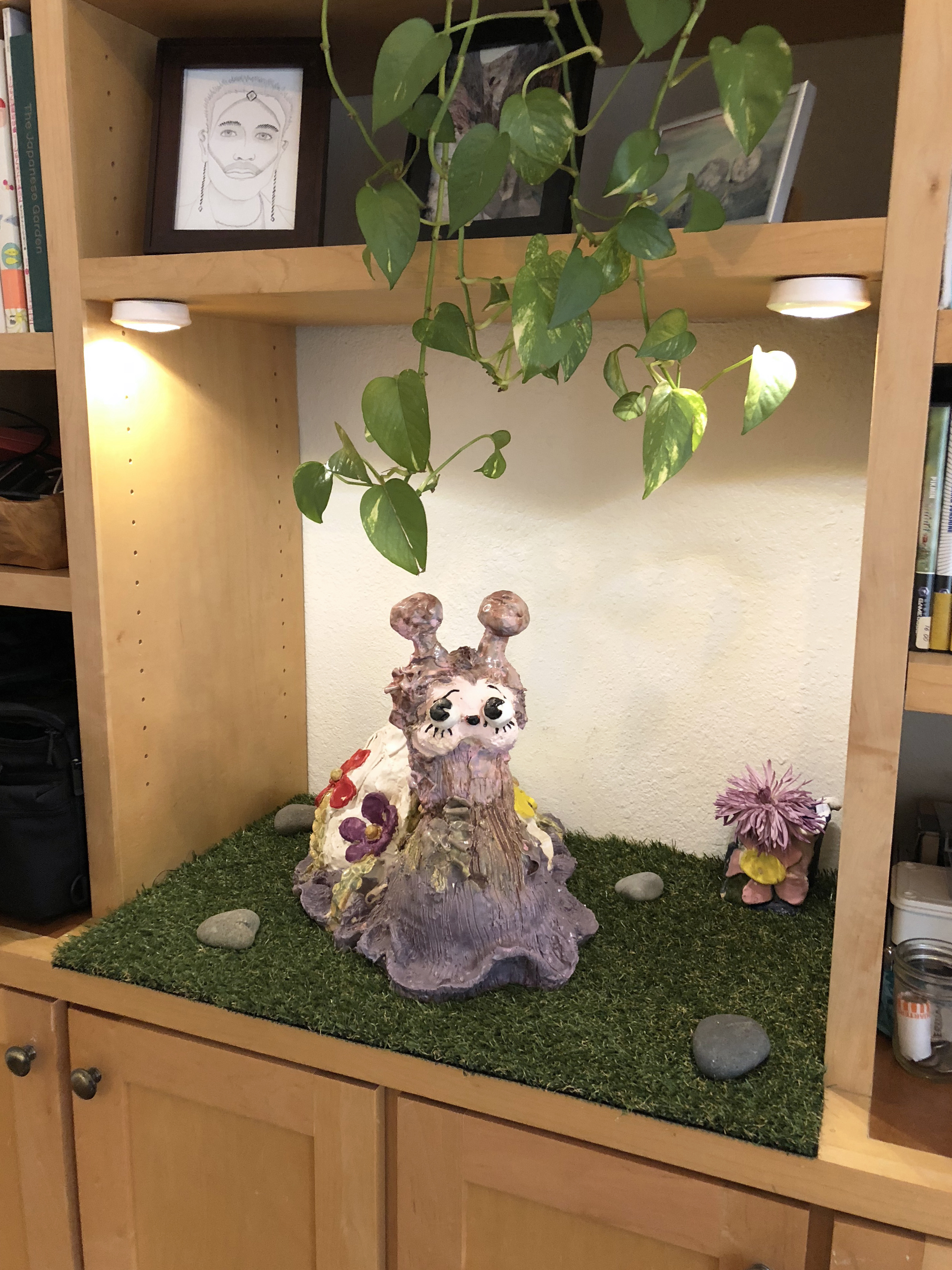 Detail of a built in entertainment center with a large ceramic snail sculpture in the center